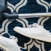 pair of white sneakers beside vacuum cleaner