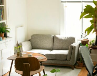 gray fabric loveseat near brown wooden table